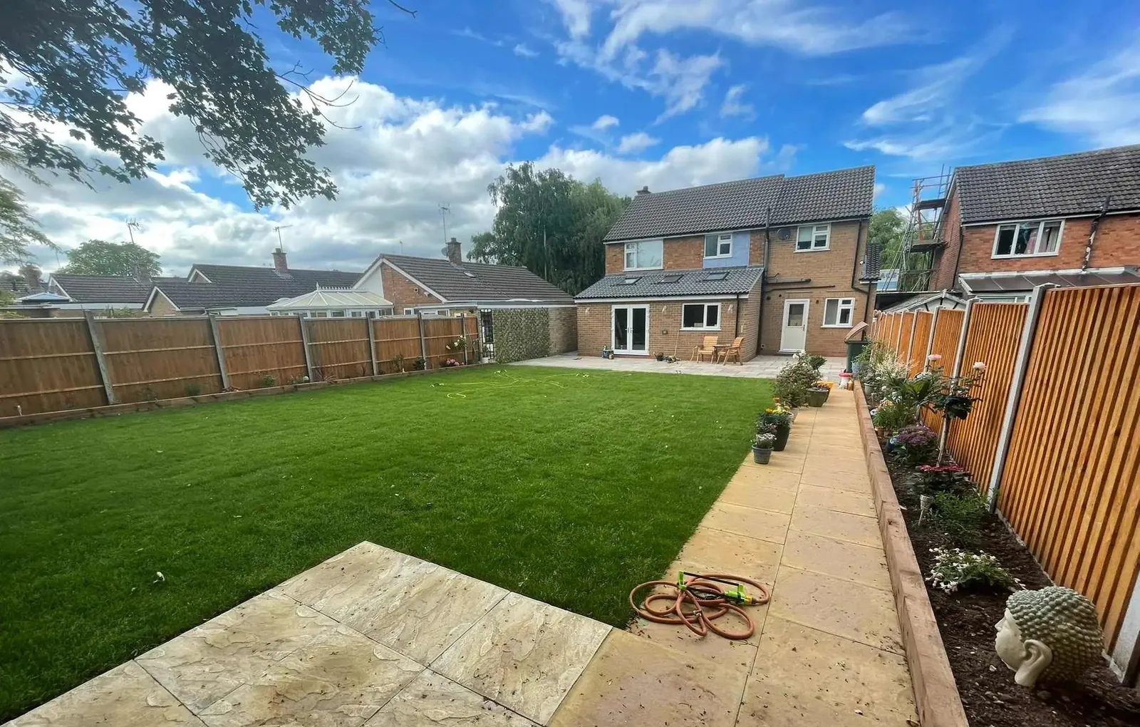 A Coventry back garden after landscaping: new sandstone patio and path, fresh lawn and close-board fencing